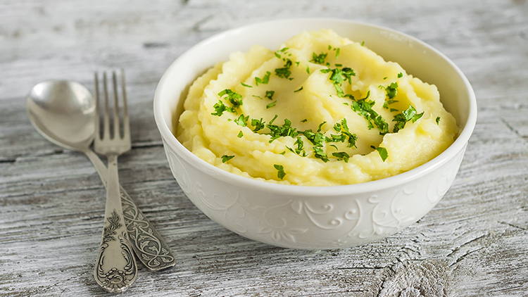 mashed potatoes in a white bowl on a light wooden background; Shutterstock ID 298896770